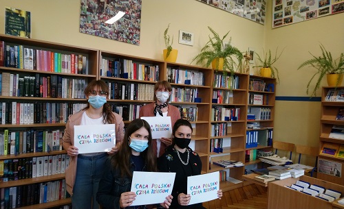 Uczennice zaangażowane w akcję czytelniczą wraz z nauczycielem bibliotekarzem